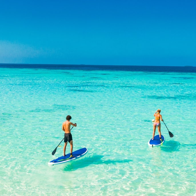 Couple paddleboarding in the maldives