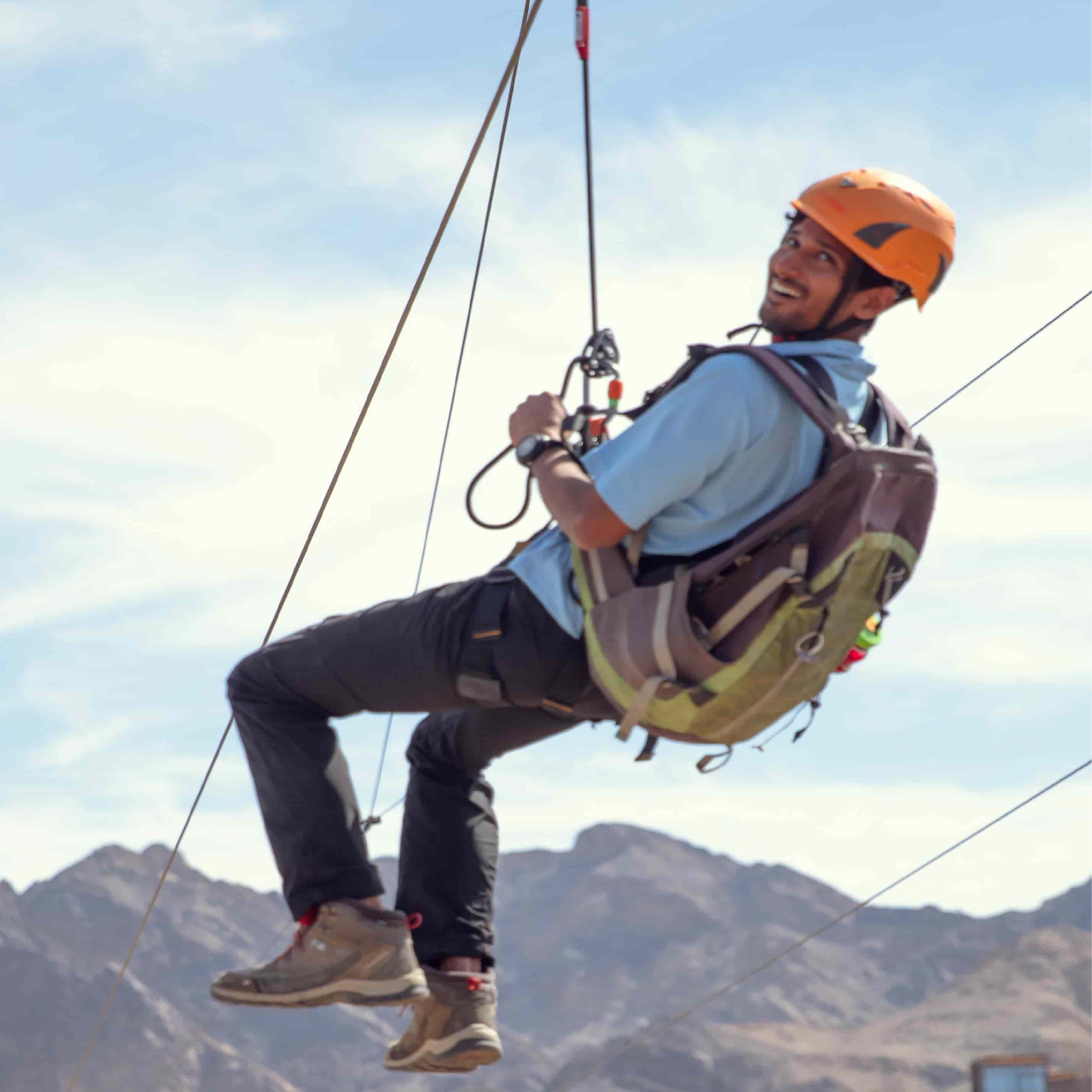 Man riding the XLine zip line
