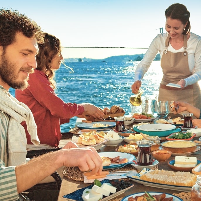 Group of friends enjoying Turkish cuisine next to the Mediterranean sea